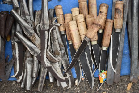 Téléchargez les photos : Un gros plan sélectif des couteaux et machettes à vendre à la foire du village en Inde pendant la journée. - en image libre de droit