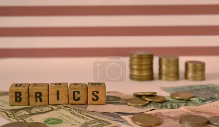 Eine Nahaufnahme selektiver Fokus Bild einer BRICS-Buchstaben vor dem Hintergrund von Banknoten und USA-Flagge