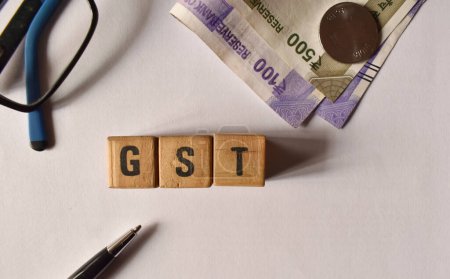 A closeup selective focus picture of a letters of GST with Indian currency.