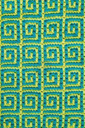 Foto de Textura tejida. Textura de tejido jacquard con patrón étnico geométrico azul amarillo. Crochet patrón de mosaico. - Imagen libre de derechos