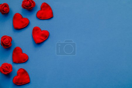 Photo for Red hearts and red roses on a blue background. Valentines day greeting card. Copy space. - Royalty Free Image