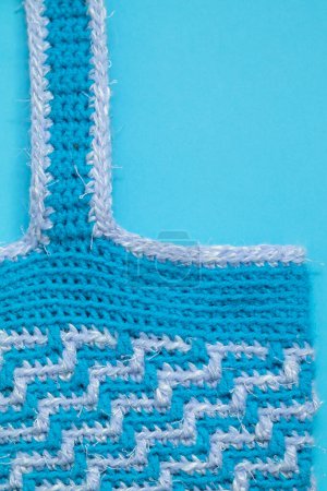 Foto de Eco friendly tote bag for shopping. Blue white crochet bag with mosaic geometric pattern on a blue background. Zero waste concept. - Imagen libre de derechos