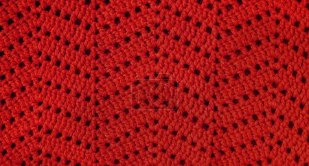 Red crochet texture with chevron stitch. Crochet fabric with zigzag pattern.