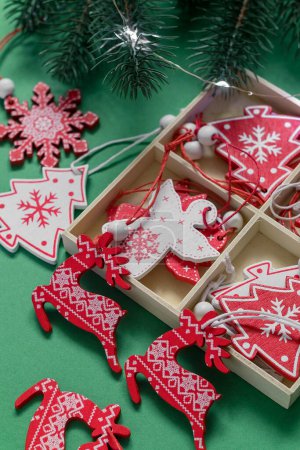 Téléchargez les photos : Boîte de Noël avec jouets en bois respectueux de l'environnement et branches de sapin sur un fond vert. - en image libre de droit