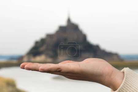 Foto de Vista panorámica de la mano sosteniendo el Mont Saint-Michel en Normandía, Francia como un tesoro - Imagen libre de derechos