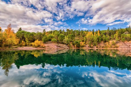 Foto de Escénica vista del espejo como reflejo del lago Carces en el sur de Francia en los colores de otoño contra el cielo dramático - Imagen libre de derechos