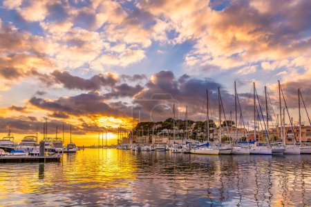 Téléchargez les photos : Vue panoramique de la mer Méditerranée contre le coucher de soleil spectaculaire de l'hiver dans le petit port de pêche de Sanary sur Mer dans le sud de la France - en image libre de droit