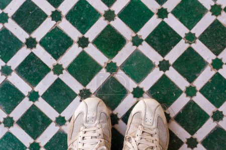 Photo for Scenic view of man sport shoes on colored tiles pattern in Marrakesh touristic spot in Morocco - Royalty Free Image