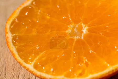Téléchargez les photos : Vue rapprochée d'une tranche de fruits orange sur une planche de bois - en image libre de droit