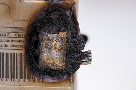 Foto de Fotografía macro de un disyuntor eléctrico quemado con plástico fundido - Imagen libre de derechos