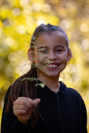 Photo for Closeup of child girl holding a branch of Silver Fern - Royalty Free Image