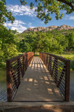 Photo for A nice footbridge leading to a hiking trail and nicely framed by lush green foliage in Wichita Mountains Wildlife Refuge in Oklahoma. - Royalty Free Image