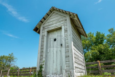 Photo for An old weathered outhouse stands as a reminder of yesteryear in this Wisconsin countryside. - Royalty Free Image