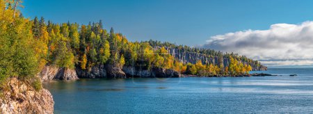 Téléchargez les photos : Comme les nuages s'accumulent au-dessus du lac Supérieur, les couleurs automnales des bois du nord du Minnesota brillent contre la côte accidentée. - en image libre de droit