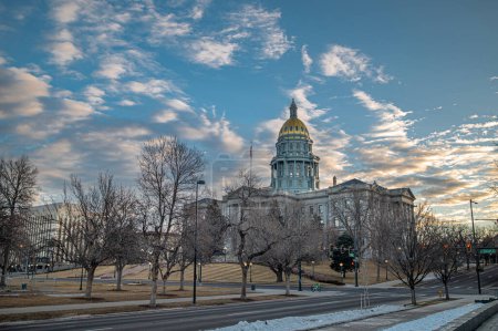 Foto de Una hermosa toma del edificio del Capitolio en Denver, Colorado mientras el sol sale detrás de él en una tranquila mañana de domingo a mediados de invierno. - Imagen libre de derechos