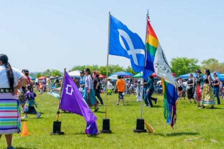Photo for Display of flags at Two Spirits Pow wow. Iroquois Confederacy. Pride flag 2-Spirited symbol and Metis flag: Toronto, Ontario, Canada - May 27, 2023. - Royalty Free Image