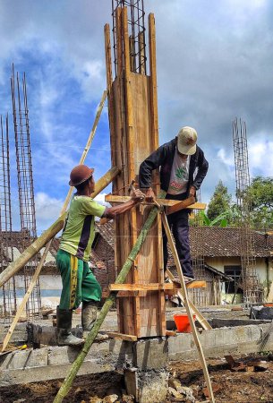 Téléchargez les photos : Magelang, Indonésie - Avril 07, 2022 : Personnes construisant une nouvelle maison dans la campagne asiatique. - en image libre de droit