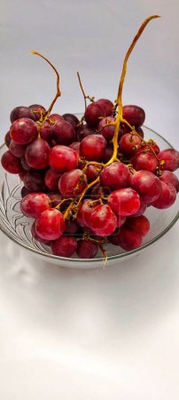 Foto de Foto de uvas en cuenco sobre fondo blanco - Imagen libre de derechos