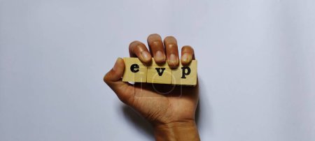 Foto de Propuesta de valor del empleado EVP. Ilustración conceptual empresarial con bloque de madera en la mano. Aislado sobre fondo blanco. - Imagen libre de derechos
