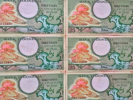 Foto de Antigua moneda indonesia Rp.25 rupias. Pila de concepto de billetes de rupias antiguas, vista superior - Imagen libre de derechos