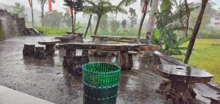 Foto de Retrato de asientos de madera y mesa en el jardín afectado por el agua de lluvia - Imagen libre de derechos