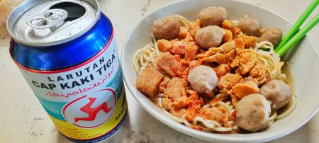 Photo for Pakis, Indonesia - June 17th, 2023. Regional culinary portrait of meatball chicken noodles in a white bowl accompanied by a drink in a can. - Royalty Free Image
