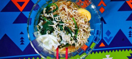 Téléchargez les photos : Soupe indonésienne aux nouilles avec garnitures de légumes et œufs durs sur le dessus. Vue du dessus - en image libre de droit