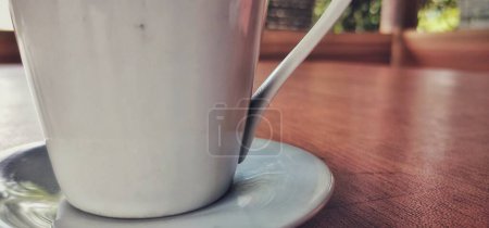 Foto de Taza de café blanco colocada sobre una mesa de madera marrón - Imagen libre de derechos