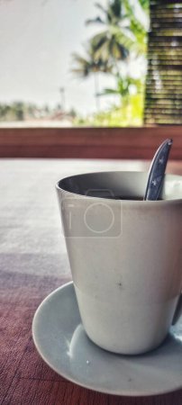 Téléchargez les photos : Portrait d'une tasse à café blanche placée sur une table en bois brun le matin. - en image libre de droit