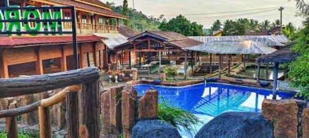 Téléchargez les photos : Belle vue grand angle sur la piscine bleue dans la villa Java centrale pendant la journée. - en image libre de droit