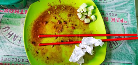 Nahaufnahme eines Fotos des Tellers nach dem Essen, man sieht mehrere schmutzige Tücher und ein Paar Essstäbchen.