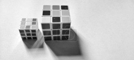 Photo for CENTRAL JAVA, INDONESIA - April 25th, 2024: Black and white photo with an abstract photo concept. Close up view of two Rubik's cubes photographed by giving a shadow effect to the object - Royalty Free Image