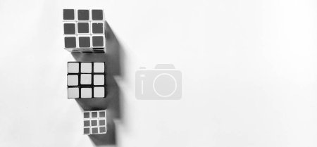 Foto de JAVA CENTRAL, INDONESIA - 25 de abril de 2024: Foto en blanco y negro con un concepto de fotografía abstracta como fondo. Vista superior de tres Rubik fotografiados dando un efecto sombra al objeto. - Imagen libre de derechos