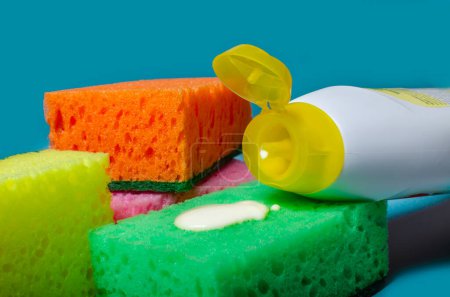 Foto de Los medios para lavar los platos y las esponjas sobre el fondo de color. tareas domésticas, lavar los platos - Imagen libre de derechos