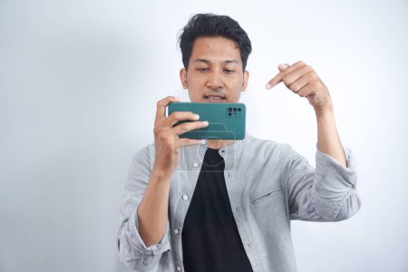 Photo for Smile please! Time for a sweet click. Closeup portrait of a young man taking a picture using a handphone - Royalty Free Image