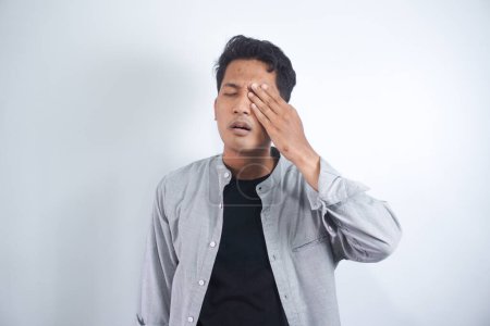 Photo for Young asian man suffering from strong eye pain. Male holding his eye felt a pain. Having migraine - Royalty Free Image