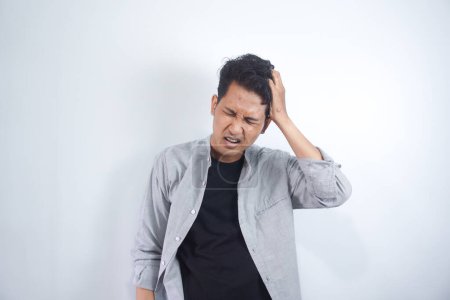 Photo for Young asian guy freelancer suffering from headache after hard working day - Royalty Free Image