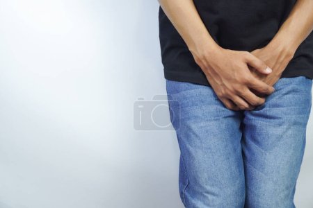 Primer plano de un hombre con las manos sosteniendo su entrepierna, concepto de infección del tracto urinario Síndrome de vejiga dolorosa y cistitis intersticial