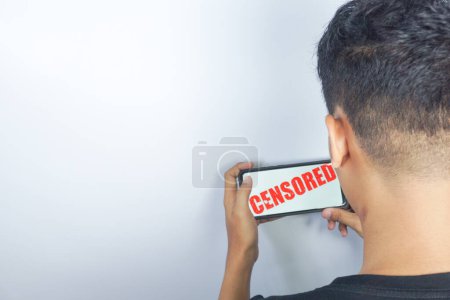 Photo for Man looking at cellphone screen and censored writing on screen - Royalty Free Image