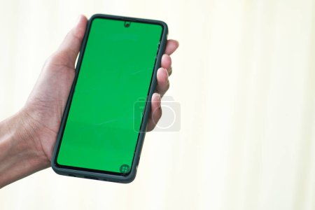 Photo for Close up of a man's hand holding a mobile telephone with a  green screen in outdoor chroma key smartphone technology cell phone street touch message display hand - Royalty Free Image