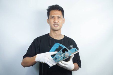Photo for Asian man wearing black tshirt holding crab machine - Royalty Free Image
