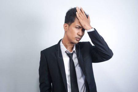 Photo for Young Asian man with hand on hip standing against white background. Frustrated man making many mistakes - Royalty Free Image