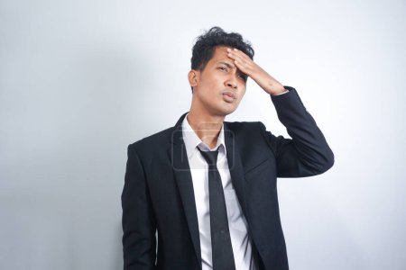 Photo for Young Asian man with hand on hip standing against white background. Frustrated man making many mistakes - Royalty Free Image