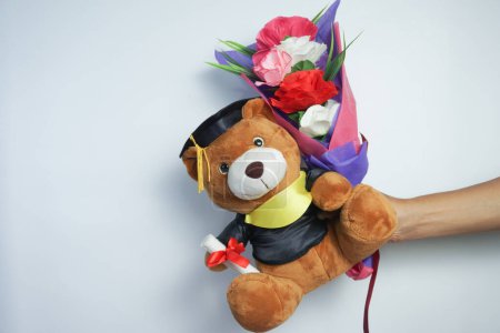 Photo for Holding and giving teddy bears and flowers on graduation day - Royalty Free Image
