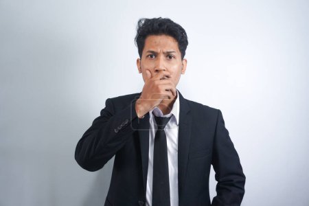 Photo for Young handsome Asian man wearing suit standing over isolated white background shocked covering mouth with hands for mistake. Secret concept. - Royalty Free Image