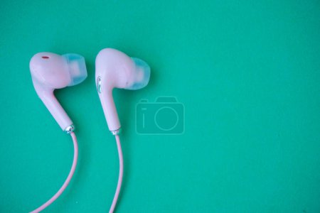 Téléchargez les photos : Écouteurs filaires roses isolés sur vert - en image libre de droit
