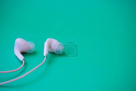Téléchargez les photos : Écouteurs filaires roses isolés sur vert - en image libre de droit