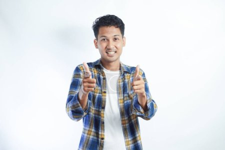 Photo for Asian man looking and pointing to camera with enthusiastic expression - Royalty Free Image