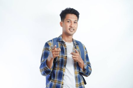 Photo for Happy fun young Asian man student in casual clothes bag glasses pointing finger at camera on you motivating encourage isolated on white background. high school university college concept - Royalty Free Image