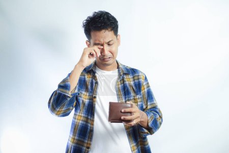 Photo for Adult Asian man looking camera with sad expression while open his wallet - Royalty Free Image